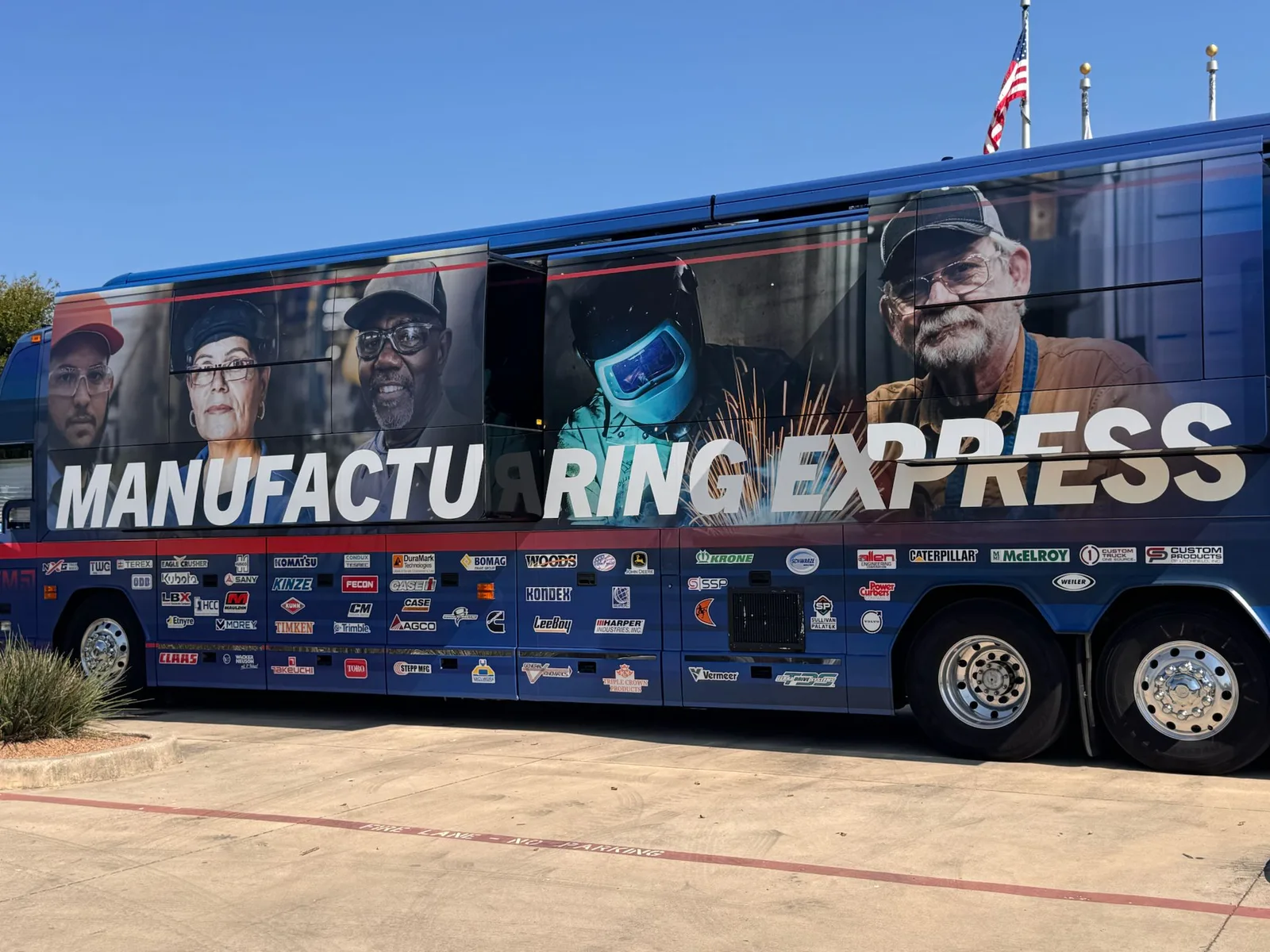A touring coach wrapped in portraits of manufacturing workers under the words Manufacturing Express
