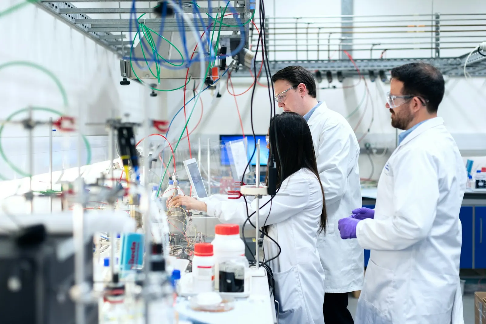 Two researchers working at a bench of laboratory glassware