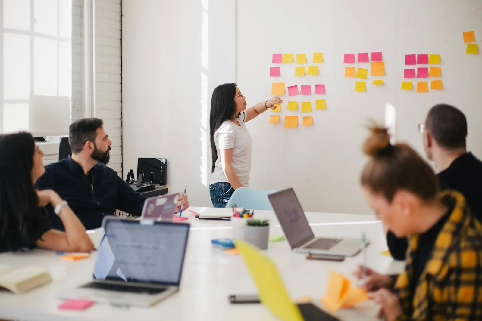 A team working through a wall of notes in a bright workshop
